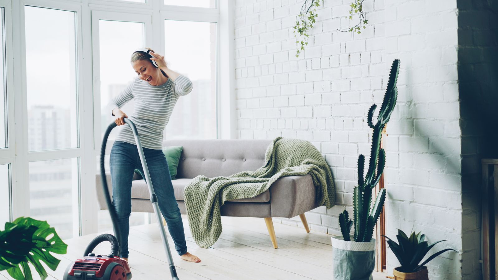 Cleaner happily vacuuming a bright living room